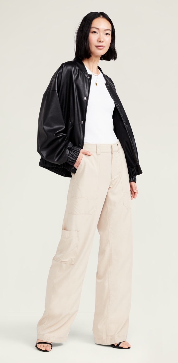 A female model in white and beige cargo pants with pockets on the legs.