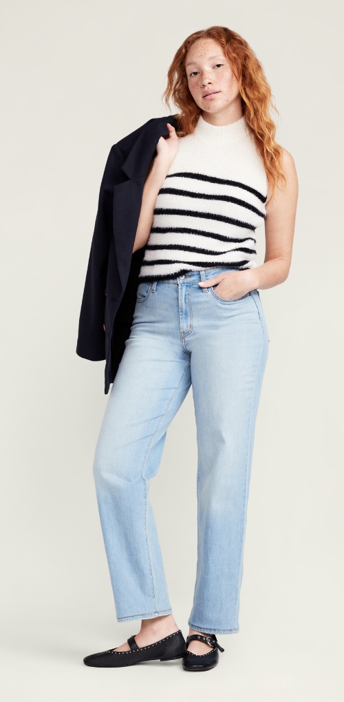 A model in a black and white striped mock neck top paired with light wash straight leg denim jeans.