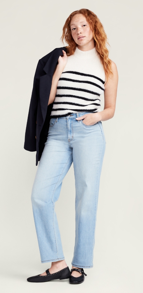 A model in a black and white striped mock neck top paired with light wash straight leg denim jeans.