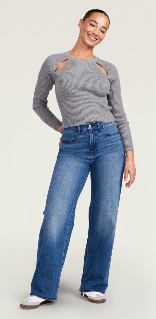 Une femme porte un jean Wow à jambe large et un haut en tricot côtelé à manches longues.