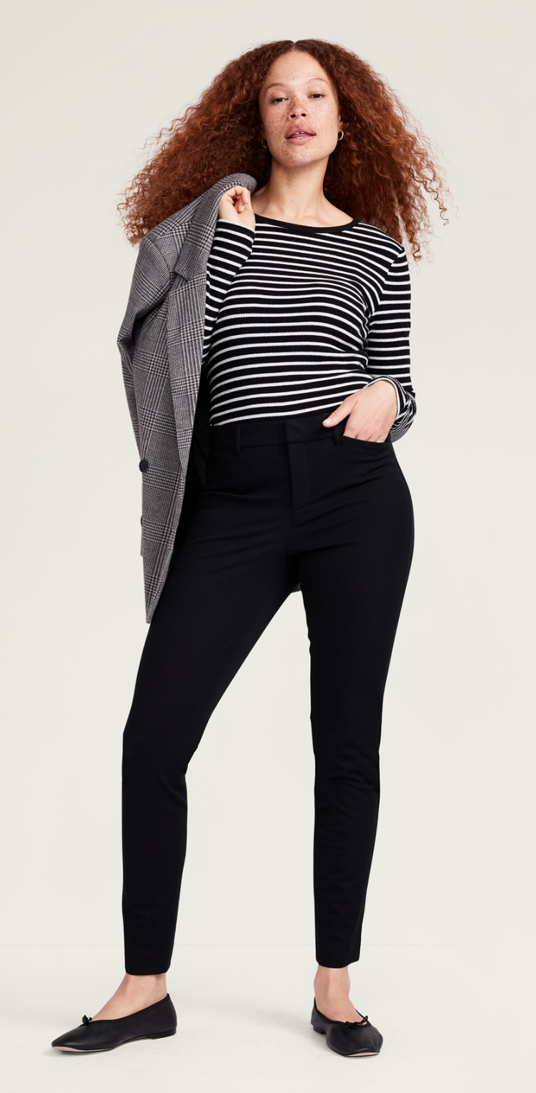 A female model in dark tapered skinny fit pants.