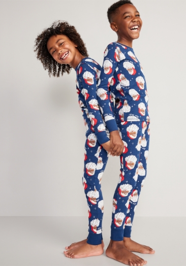 Two young models wearing gender-neutral printed pajama sets.