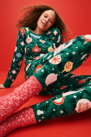 A female model wearing a Christmas-themed pajama set