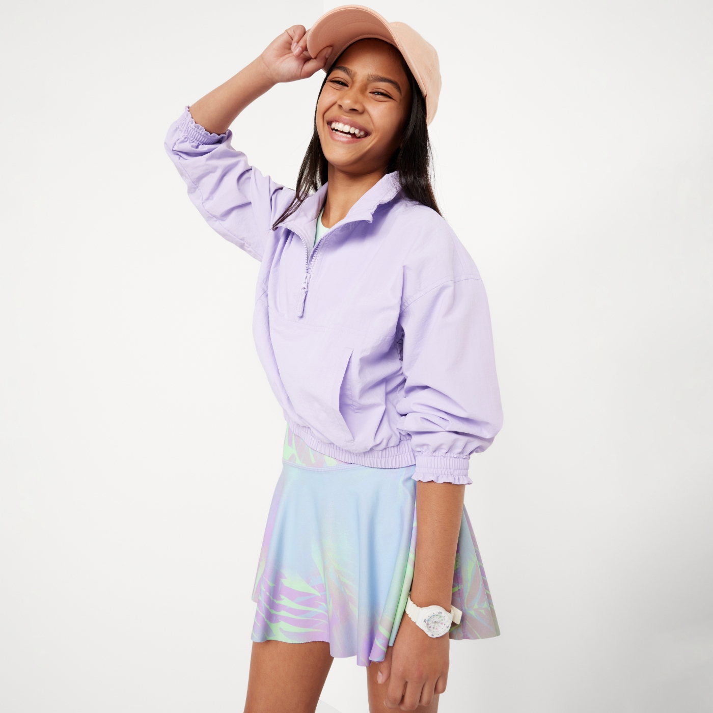 Young girl model wearing quarter-zip light purple sweatshirt and skort.