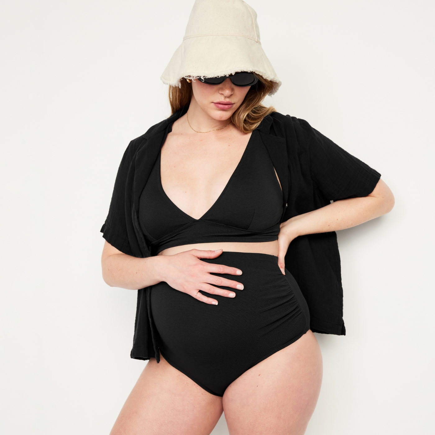 A maternity model dressed in beach attire.