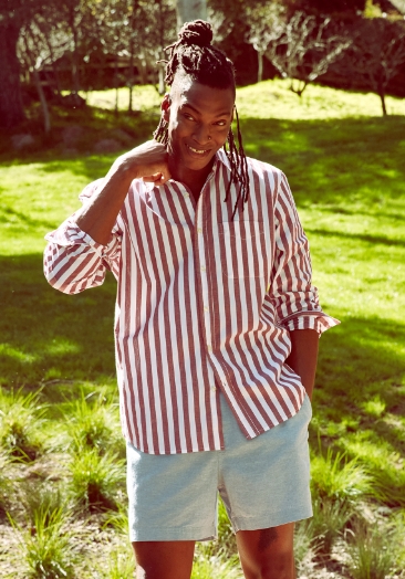 Male model wearing stripe button-down shirt and grey shorts.