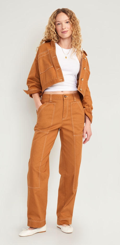 A burnt orange utility pant with exposed white seams, paired with a matching jacket and tank top.