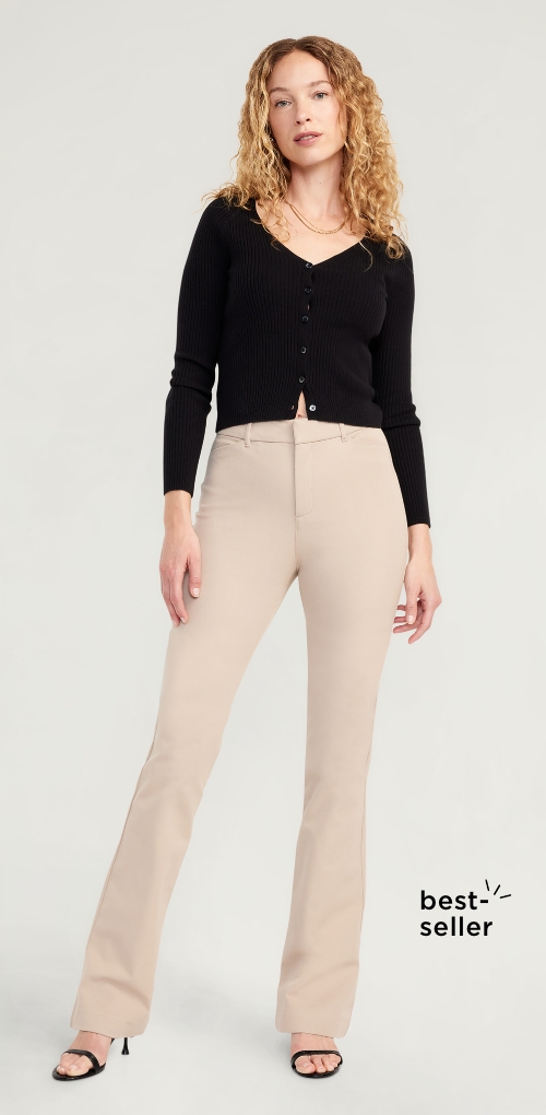 A female model wearing high waist light colored flare style pants.