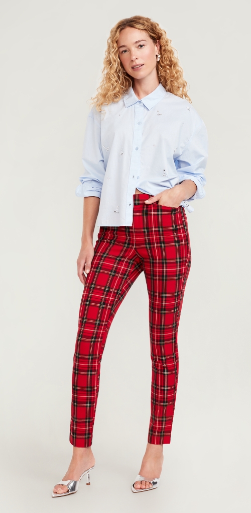 A woman dressed in plaid holiday pants that taper at the ankle.