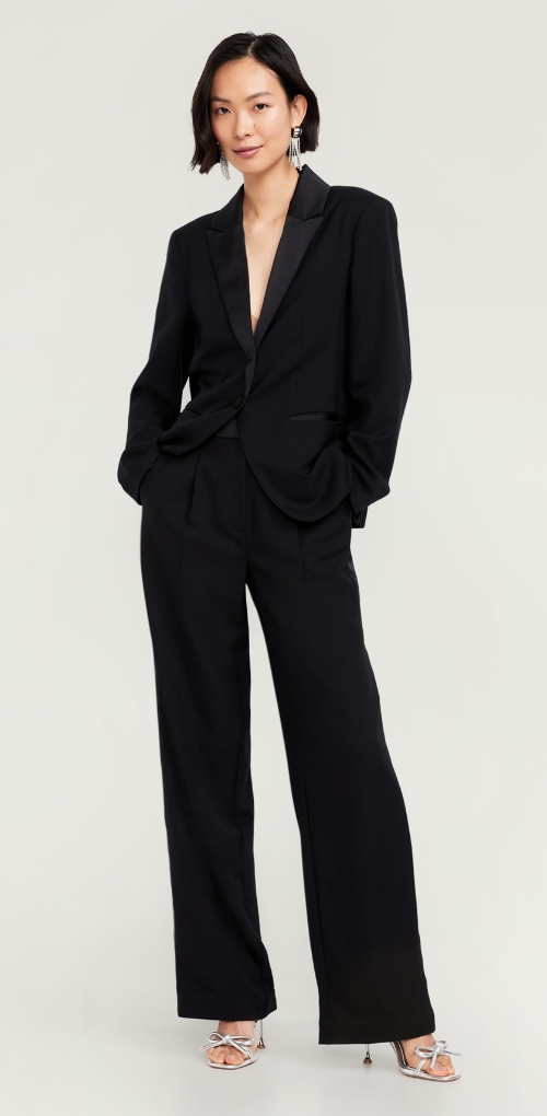 A woman in a black wide leg pant suit.