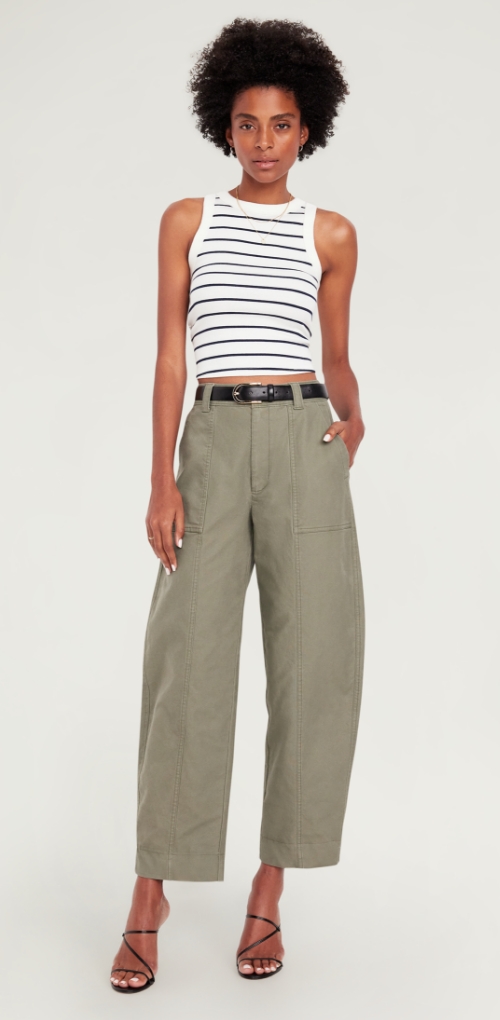 A woman dressed in barrel leg olive green pants.