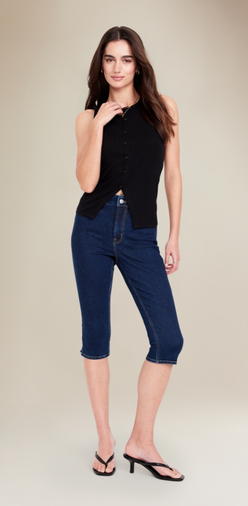 A female model in a dark wash fitted capri jean.